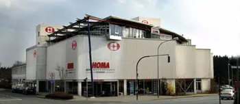 Weißes HOMA Gebäude mit Eingängen, Straßenkreuzung, Ampeln und geparkten Autos